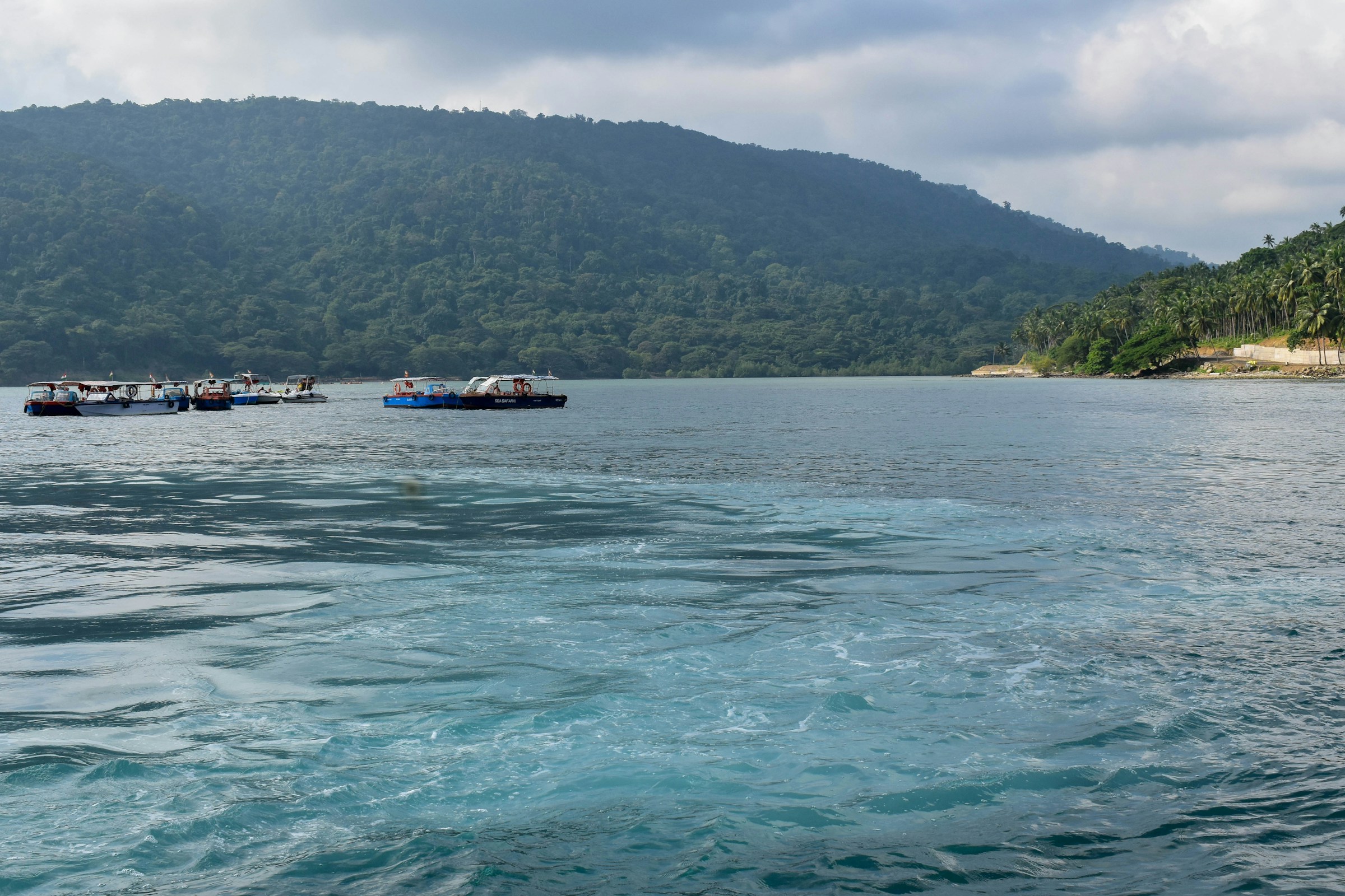 A group of boats floating on top of a large body of water