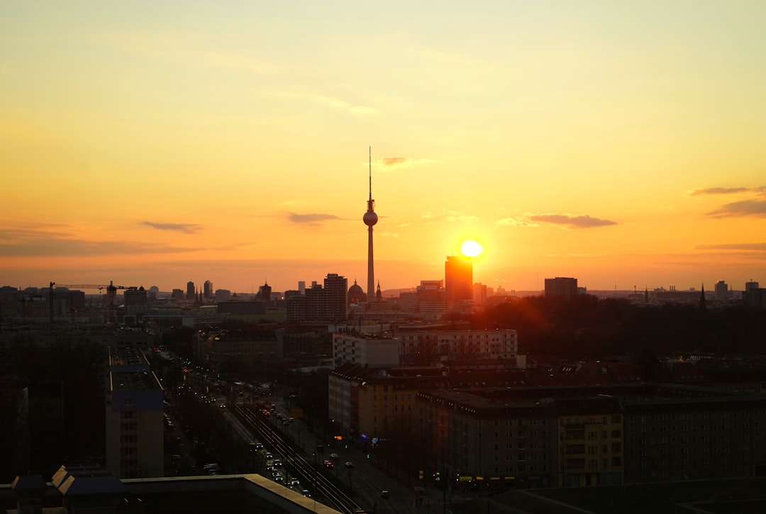 the sun is setting over a city with tall buildings