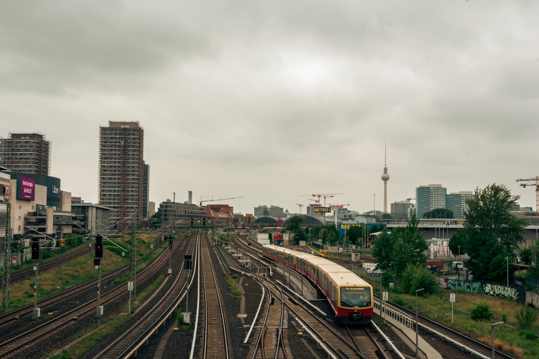 Train traveling through a city with an overcast sky.