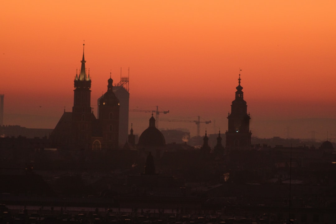 City skyline silhouette against an orange sunset sky.