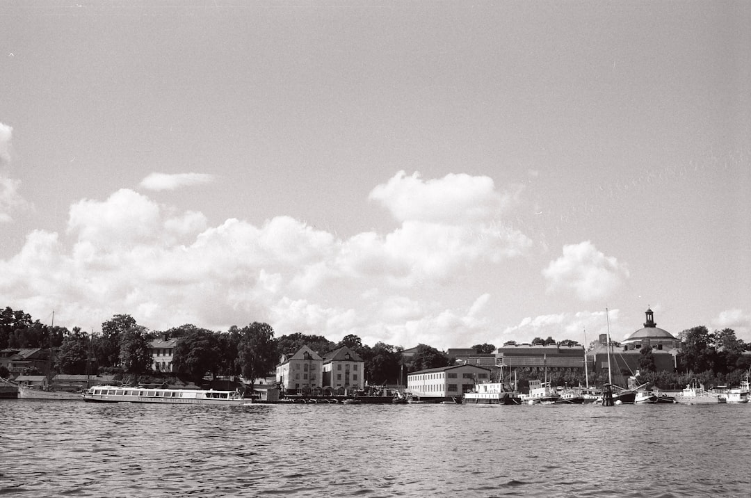 grayscale photo of city buildings near body of water