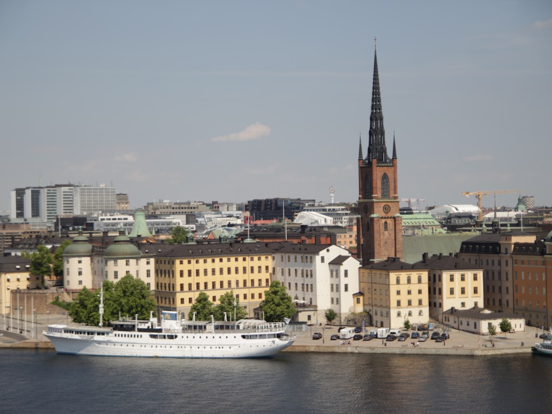 White cruise ship docked near historic european city buildings.