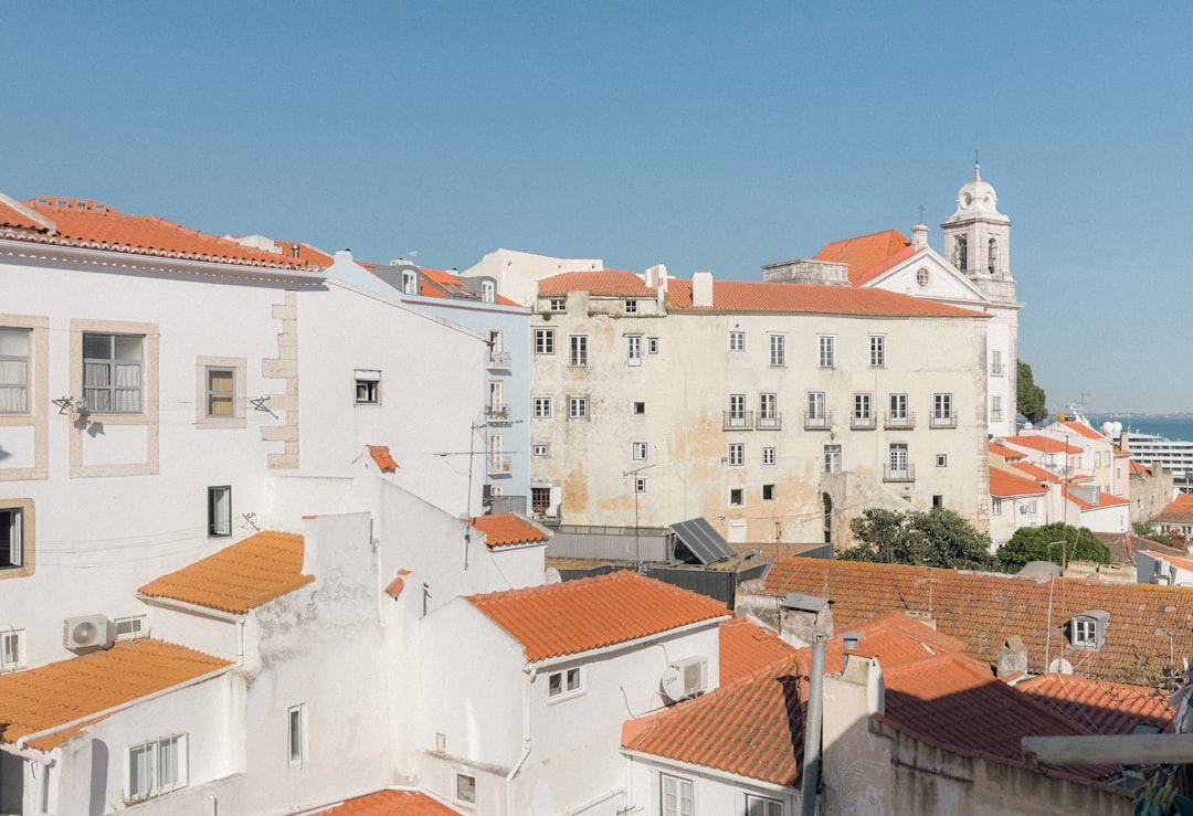 White buildings with orange roofs under blue sky.
