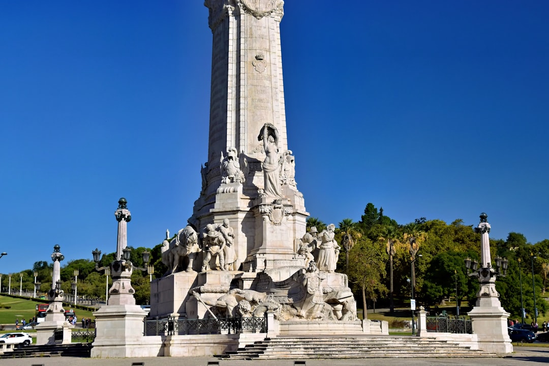 Monumental stone structure with statues against blue sky