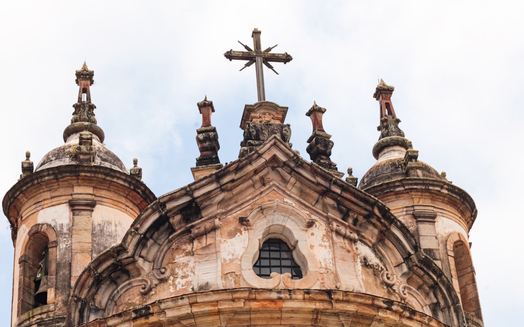 Close-up of a historic church facade with a cross.