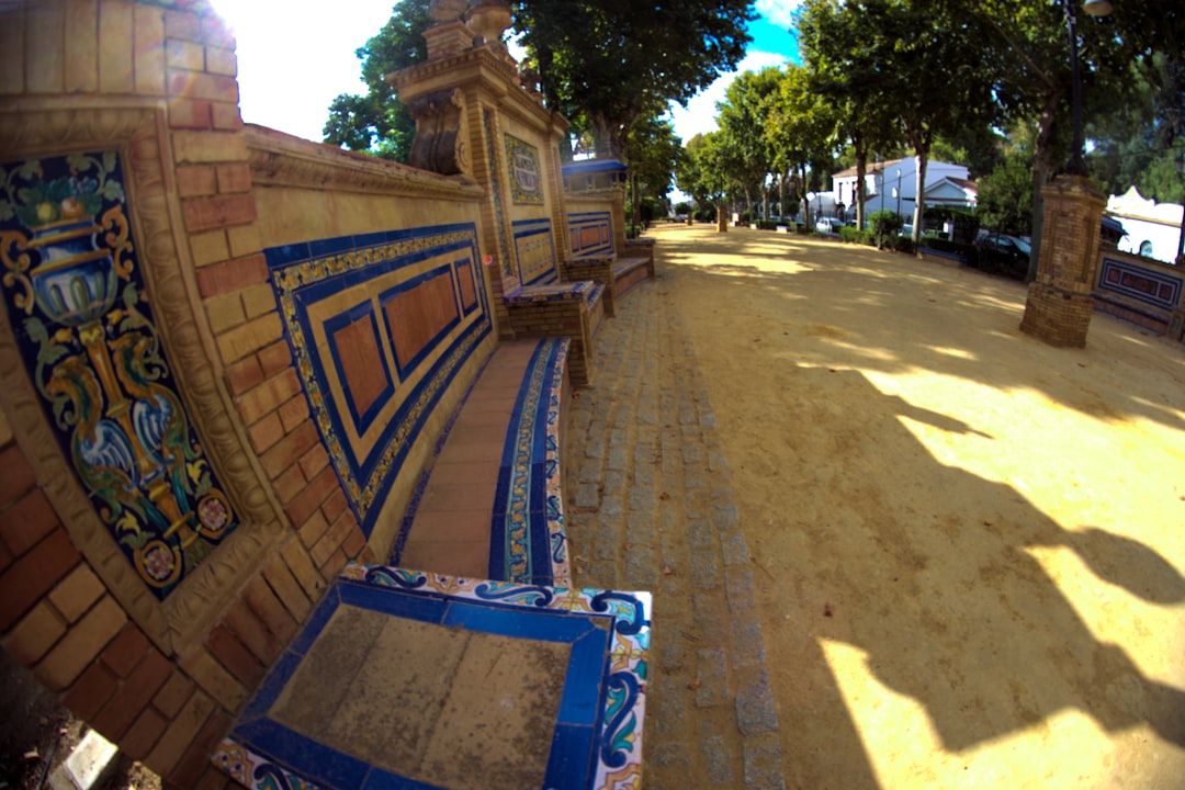 Ornate tiled bench in a sunny park path.
