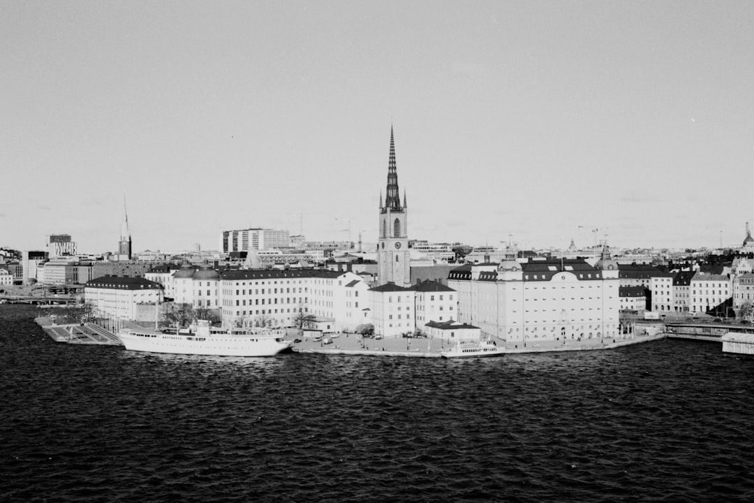grayscale photo of city buildings near body of water